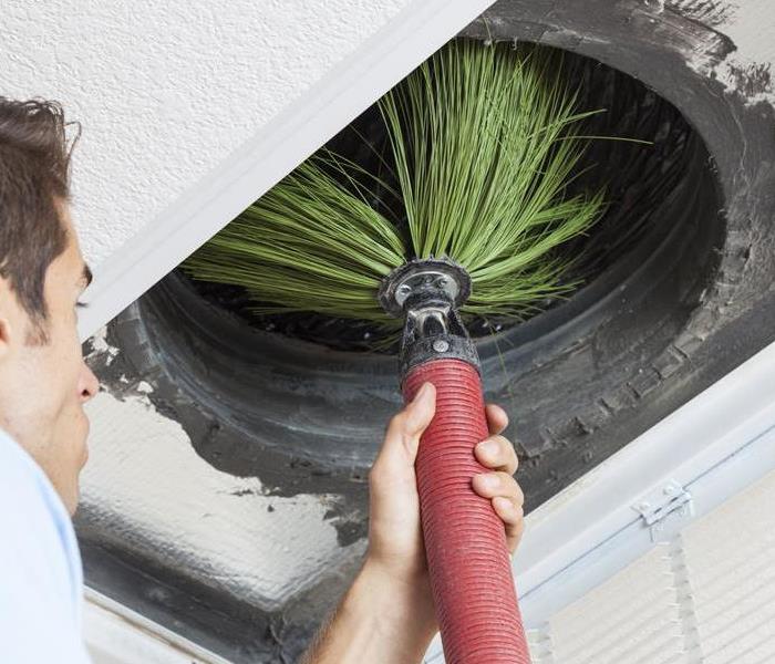 male cleaning duct with big broom