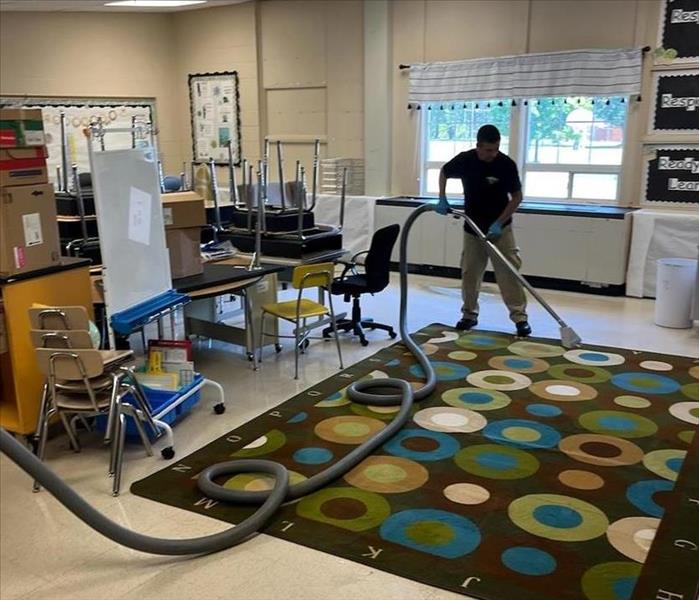 Vacuuming a classroom with desks and chairs