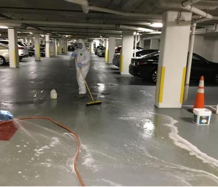 Men in biohaz suits cleaning parking garage
